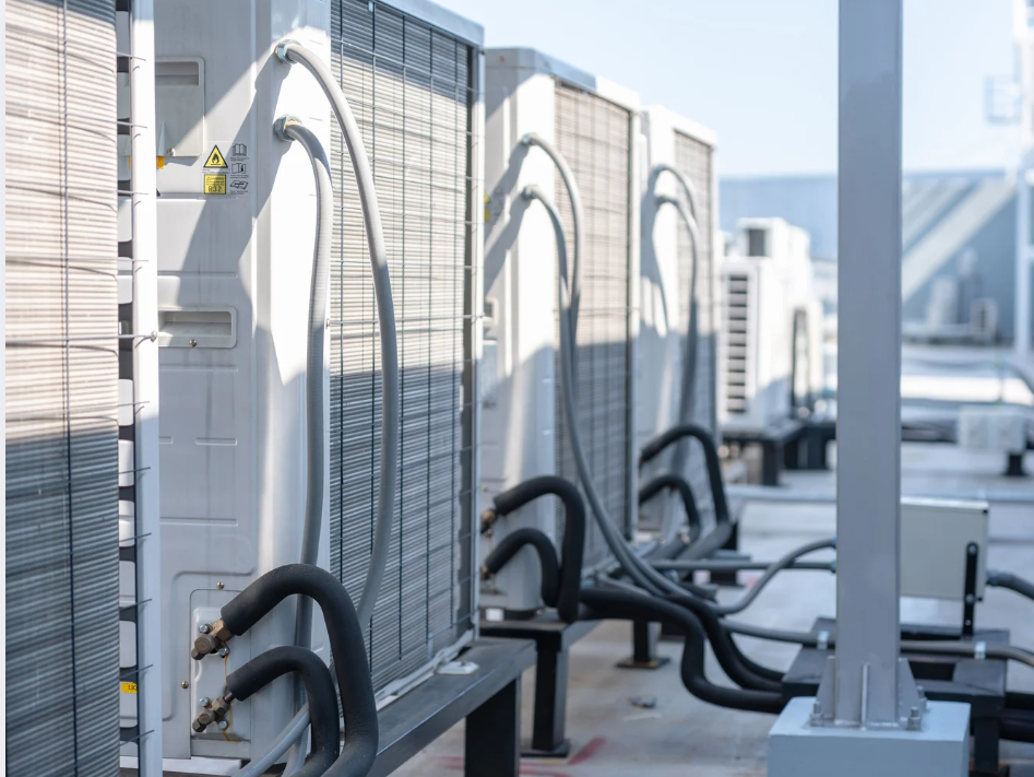 Commercial HVAC units installed on rooftop with connected piping and ventilation systems